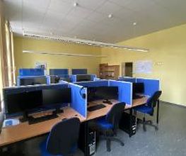 Ein Arbeitsbereich mit mehreren PC-Arbeitsplätzen, die durch Sichtschutzwände getrennt sind.