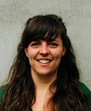 Portrait einer Bildungsreferentin mit schwarzen langen Haaren. Die Dame lächelt freundlich in die Kamera.