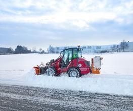Weidemann Hoftrac 1260LP mit Schneeschild und Salzstreuer im winterlichen Einsatz
