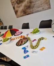 Ein langer Tisch mit Donuts, Süßigkeiten und Weintrauben sowie Fußballdekoration zum Anlass der EM.