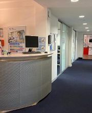 Empfangstheke und Flur mit mehreren Türen.