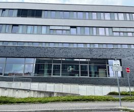 Außenansicht des Gebäudes. Dunkelgrauer Klinker und viele Fenster.