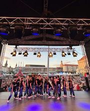 D.D.Project - Hip-Hop Tanzschule Dresden Tanzgruppe bei einem Open-Air-Auftritt auf einer Stadtfestbühne vor einer großen Menschenmenge, perfekt für Event- und Showdance-Inhalte.
