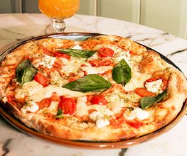 Mauritius Pizza, unsere knusprig-luftige Pizza besteht aus einem Sauerteig, der aus Weizen-, Reis-, Mais- und Sojamehl hergestellt wird und 72 Stunden ruht. Jede Pizza wird bei uns mit Fior die Latte Mozzarella zubereitet, mit Liebe belegt und mit Olivenöl Extra Vergine verfeinert.