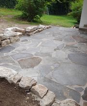 Terrasse mit Porphyrplatten und Sandsteinmauer