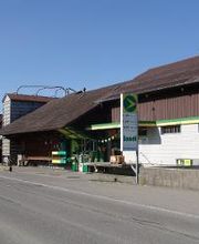 AGROLA Tankstelle in Waldkirch; bei Landwirtschaftsgebäude gelegen. Im Vordergrund Strasse und Totem mit Preisanzeige AGROLA Diskus und Landi Logo