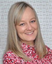 Eine Bildungsreferentin des Standortes Bitterfeld/ Wolfen. Blonde Haare, rot-geblühmte Bluse und sympathischer Blick in die Kamera.