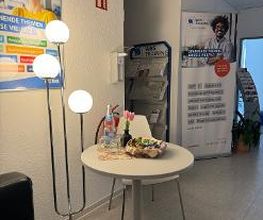 Aufenthaltssbereich mit kleinem runden Tisch und Couch mit Stehlampe