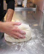 pétrissage de la pâte à pizza Bio au pétrin et à la main plusieurs fois avant le boulage des pâtons.