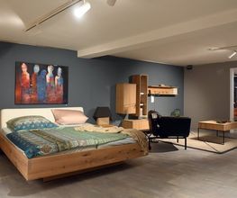 Schwebebett aus Massivholz und passende Kommoden in der Ausstellung von Möbel Schmitz in Trier. Erleben Sie langlebige Schlafzimmermöbel aus natürlichen Materialien live vor Ort in der Saarstraße.