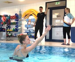 Schüler:innen trainieren im Schwimmbecken für die Ausbildung "Masseur:in und medizinische Bademeister:in".