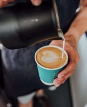FirstLoveCoffee GmbH - Kaffee Catering Berlin - Nahaufnahme von Latte Art im Kaffeebecher, zubereitet vom Barista für Event Catering, Cappuccino-Service und hochwertige Kaffeespezialitäten.