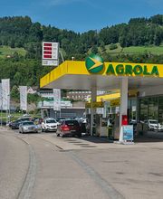 AGROLA Tankstelle und LAVEBA Shop in Wattwil bei Autogarage; direkt an Strasse; grosse digitale Preisanzeige über Tankstellen-Dach; Autos an Strasse geparkt