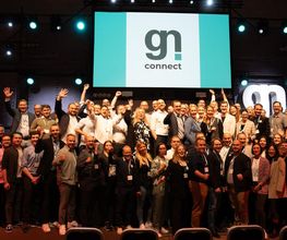 Eine große Gruppe von Menschen steht auf einer Bühne vor einer Leinwand mit dem Logo von „gn connect“. Es handelt sich um eine Veranstaltung, bei der eine Gemeinschaft aus der Gastronomie- und Digitalisierungsbranche zusammenkommt, im Rahmen gastronovi-Events gn connect in Bremen in der alten Werft.