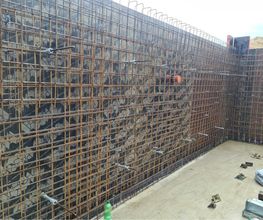 Bewehrung für eine hohe Stahlbetonwand in der Baugrube, kurz vor dem Betonieren. Rohbau von AS-Bau.