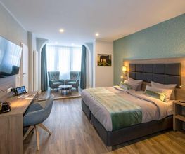 30 m² Komfort Doppelzimmer Nr. 21 im Haupthaus (1. Etage): Maximaler Schlafkomfort im 1,80 x 2,10 m Überlängen-Bett mit Komfortmatratze und XL-Decken. Inklusive 55″-Smart-TV, Qi-Ladestation, Laptopsafe sowie Bad mit XL-Tüchern und viel Ablagefläche