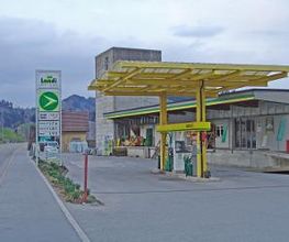AGROLA Tankstelle in Urnäsch; gelbes Glasdach; im Hintergrund Beton-gebäude von Landi