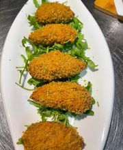 Knusprige panierte Tapas auf Rucola. "Croquetas".
