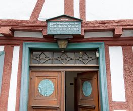 Haustüre vom Gästehaus "Ingrid", ein Historisches Haus von 1699, mit einem Schild über der Eingangstüren, welches Wahrheit sagt. 