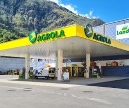 AGROLA Tankstelle in Eyholz mit TopShop und Landi Laden, im Hintergrund Landi Gebäude, Tankstelle überdacht, mehrere Tanksäulen, Berg im Hintergrund