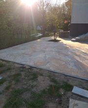 Großzügig angelegte Terrasse mit hellen Natursteinplatten und integrierter Pflanzfläche. KK GaLaBau in Berlin Reinickendorf gestaltet individuelle Terrassen, die Wohnhaus und Garten funktional miteinander verbinden.