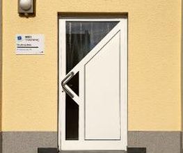 Außenansicht vom Eingang. Weiße Türe, links daneben ein WBS TRAINING Schild. Gelbe Fassade.