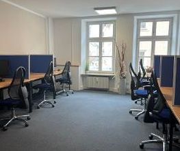 Schulungsraum mit 6 Arbeitsplätzen und 2 Fenstern. Ausgestattet mit jeweils 2 Bildschirmen, einem Bürostuhl, Tastatur und Maus.