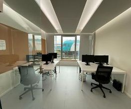 Schreibtische mit zwei Bildschirmen, Maus, Tastatur und Headset