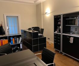 Arbeitsbereich von A. Hampel mit Schreibtisch, Büroeinrichtung und integrierter Teeküche.