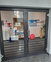 Eingangstür im Treppenhaus Flur. Glastüre mit blauem WBS TRAINING Schriftzug und Logo.