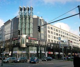  Plaza Frankfurter Allee mit Ampeln und Straße mit Autos im Vordergrund.
