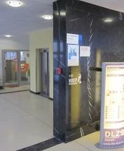 Empfangshalle mit Schildern und Aufzügen.