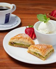 Baklava Plate: Sweet, delicious baklava stuffed with chopped pistachios and served with a scoop of vanilla bean ice cream.