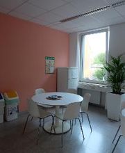 Teilnehmerküche mit hellen Möbeln und Zimmerpflanze. Die Wand ist korallfarben gestrichen