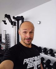 LIFE PERFORMANCE TRAINING | Personal Training Nürnberg - Trainer-Selfie im hellen Krafttrainingsbereich mit Kurzhanteln und moderner Ausstattung. Das Motiv eignet sich für Keywords wie Fitness Coaching, Personal Trainer Nürnberg, private Fitness und betreutes Krafttraining.