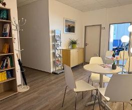 Aufenthaltsbereich mit Bücherregal runden tischen und Sitzgelegenheiten