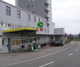 AGROLA Tanktstelle in Waldkirch. Rechts im Bild Strasse. Links AGROLA Tankstelle an Gebäude gelegen. Überdacht mit digitaler Preisanzeige.