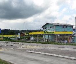 AGROLA Tankstelle in Buttisholz mit TopShop und Landi; im Vordergrund Strasse mit Fussgängerstreifen, links Totem mit Landi Schild, AGROLA Schild, digitaler Preisanzeige Treibstoff, selfwash dach 