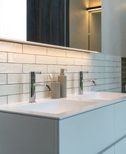 Modernes Badezimmer mit stilvollem Doppelwaschtisch und hochwertigen Armaturen – ein Beispiel für präzise Sanitärtechnik und zeitgemäßes Design.