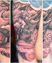 Realistisches Black-and-Grey-Tattoo einer Abenteurerin, die auf einem Alligator reitet, mit Peitsche, Wolken und dynamischer Action-Szene.