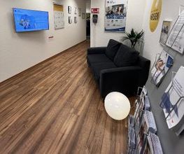 Ein Gang mit einer schwarzen Couch.