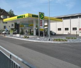 AGROLA Tankstelle in Siebnen, Wangen; überdachte Tankstelle; links Gitter n Aufnahme. Rechts Gebäude neben Tankstelle.