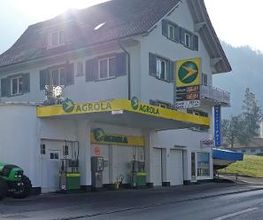 AGROLA Tankstelle in Vitznau mit zwei Tanksäulen und Zahlterminal bei einem Wohnhaus