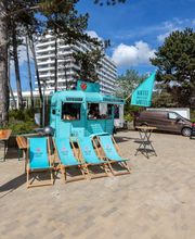 FirstLoveCoffee GmbH - Kaffee Catering Berlin - Türkiser Kaffeeanhänger mit Liegestühlen und Beach-Atmosphäre für Outdoor Catering, Bio-Kaffee, frische Waffeln und mobilen Barista-Service.