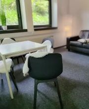 Pausenraum mit Tisch und Stühlen sowie einem Sofa.