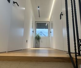 Exklusive Flurgestaltung mit wandbündigen Filomuro-Türen, abgehängter Decke, präzisen Schattenfugen, Q4-Oberflächen und hochwertigem Parkettboden.