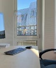 Beratungsplatz mit Blick aus dem Fenster. Auf dem Schreibtisch befindet sich ein PC-Bildschirm, eine kabellose Tastatur und Maus sowie Notizblöcke und Stiftebecher.