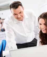 Zwei Teilnehmer:innen vor dem Laptop.