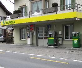 AGROLA Tankstelle in St. Erhard - Knutwil; zwei Tanksäulen mit Zahlterminal und digitaler Preisanzeige; an Wohnhaus gelegen; über AGROLA Dach direkt Balkon von Wohnhaus