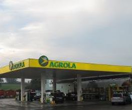 AGROLA Tankstelle in Rothenburg; regnerische Aufnahme, rechts Autos geparkt und daneben TopShop Laden